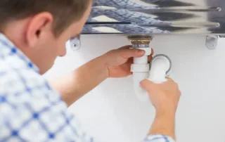 Plumber cleaning a bathroom sink drain